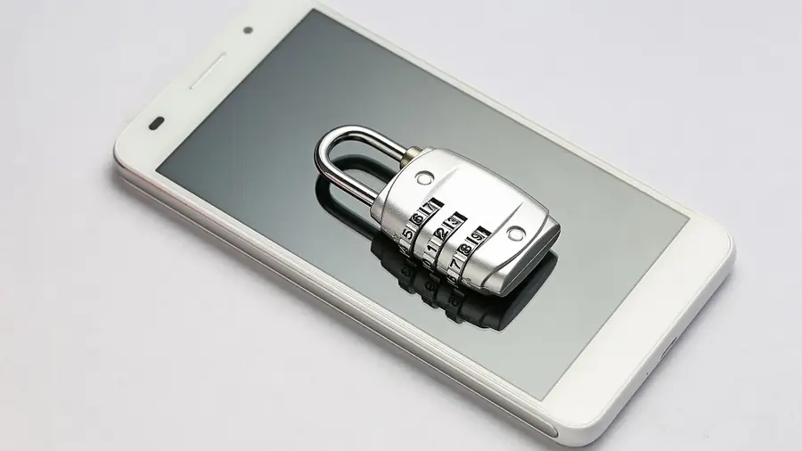Combination padlock resting on a smartphone, symbolizing security